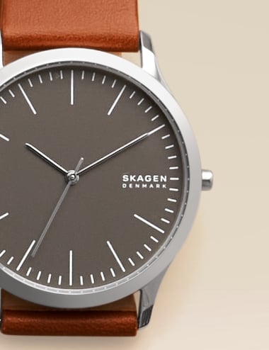 Eine silberfarbene Skagen Uhr mit braunem Lederband