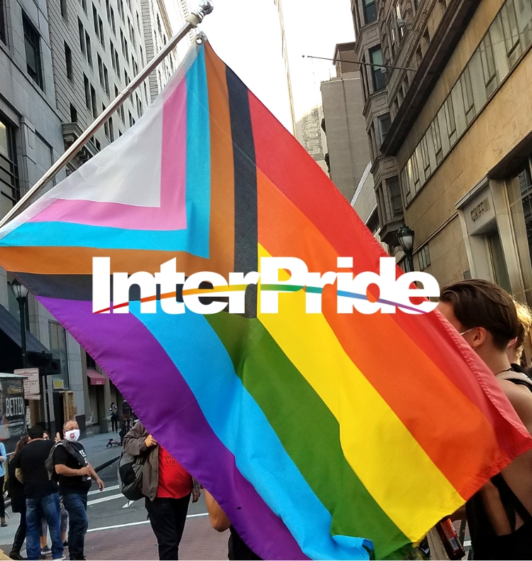 Image of a Pride flag hanging on the side of a building