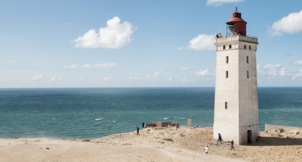 a lighthouse on the beach overlooking the ocean