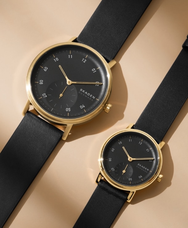Two black and gold tone Skagen watches.