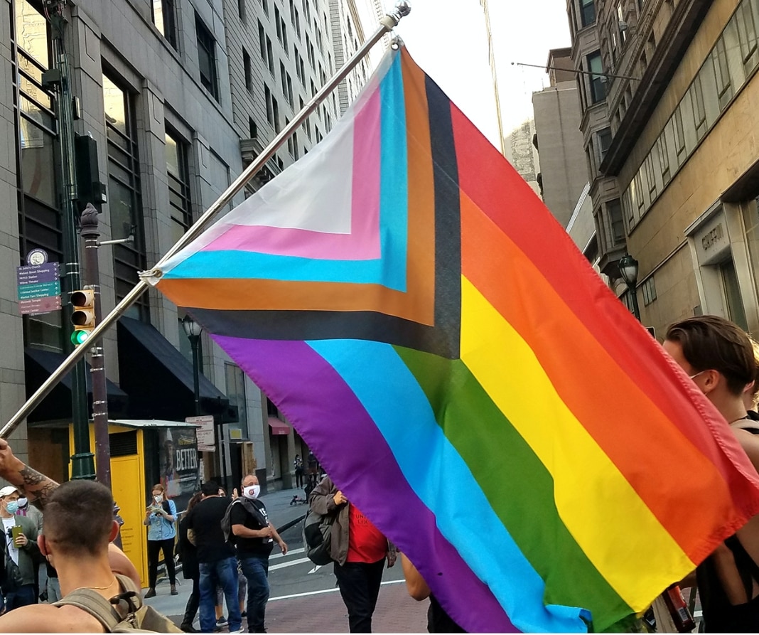 Image of the Pride flag on a city street.
