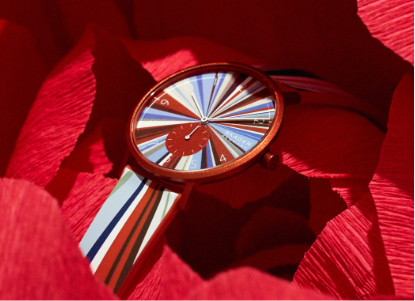 a red aaren colorburst watch on a red tissue paper background