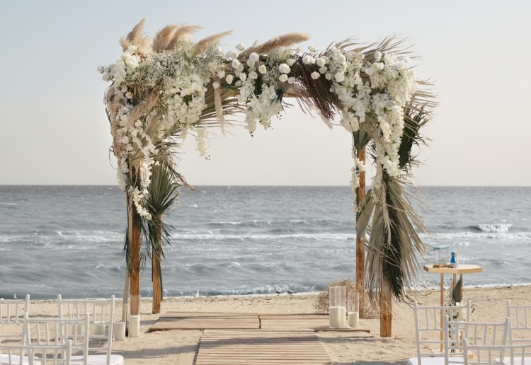 Wedding archway on a beach and Woman wearing a Skagen watch and jewelry