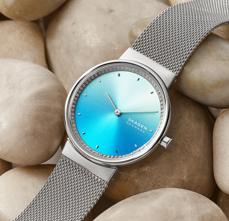 Silver-tone case with matching mesh strap and blue dial.