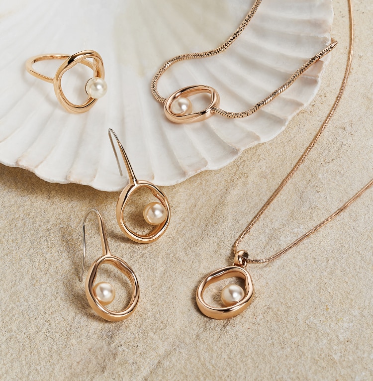 A matching ring, bracelet, earring and necklace set in rose gold-tone with a pearl inset.
