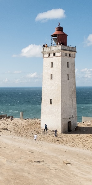 Ein Leuchtturm am Strand vor dem Meer