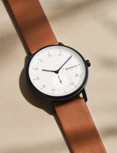 Image of a circlular watch with a white dial and brown leather strap