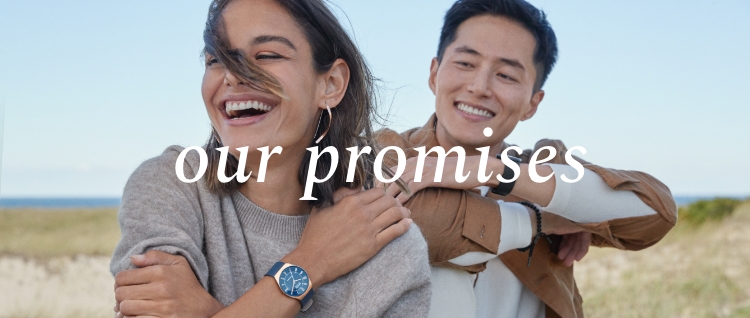 Image of a woman and a man sitting on a sand dune, wearing Skagen watches